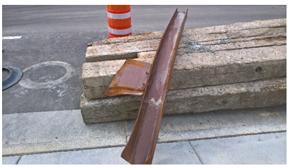 orange cone next to pile of wood in street